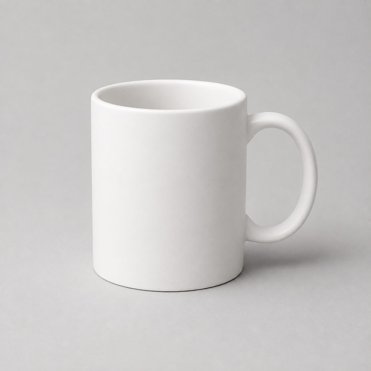Plain white mug photographed alone on a light grey background