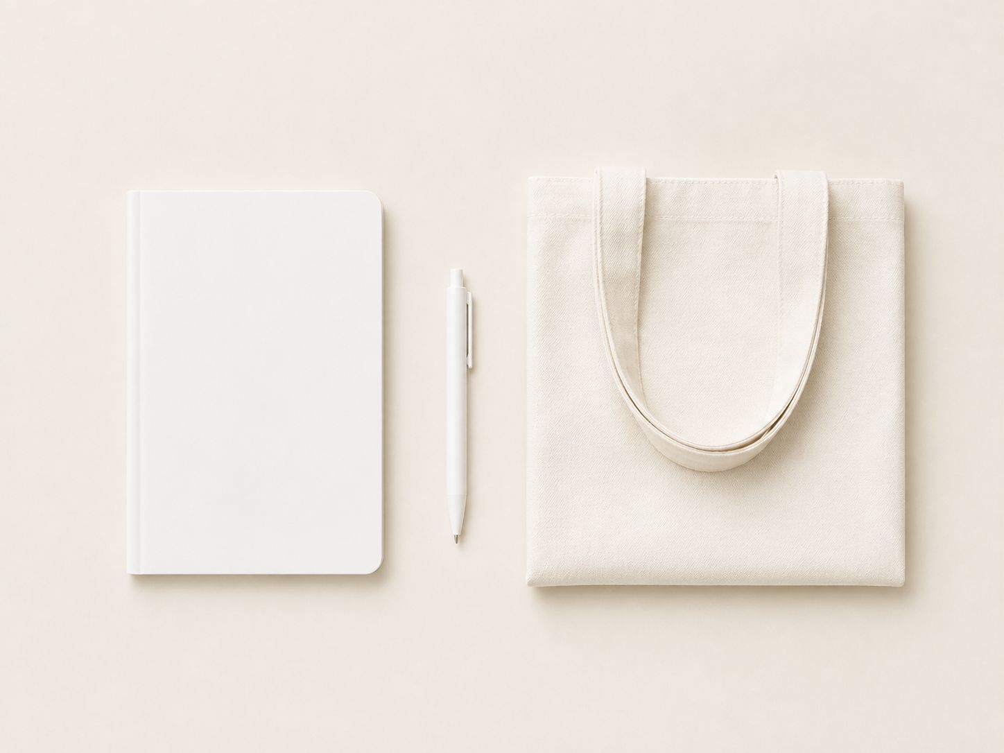 Minimal flat lay of a blank notebook, pen and folded tote bag
