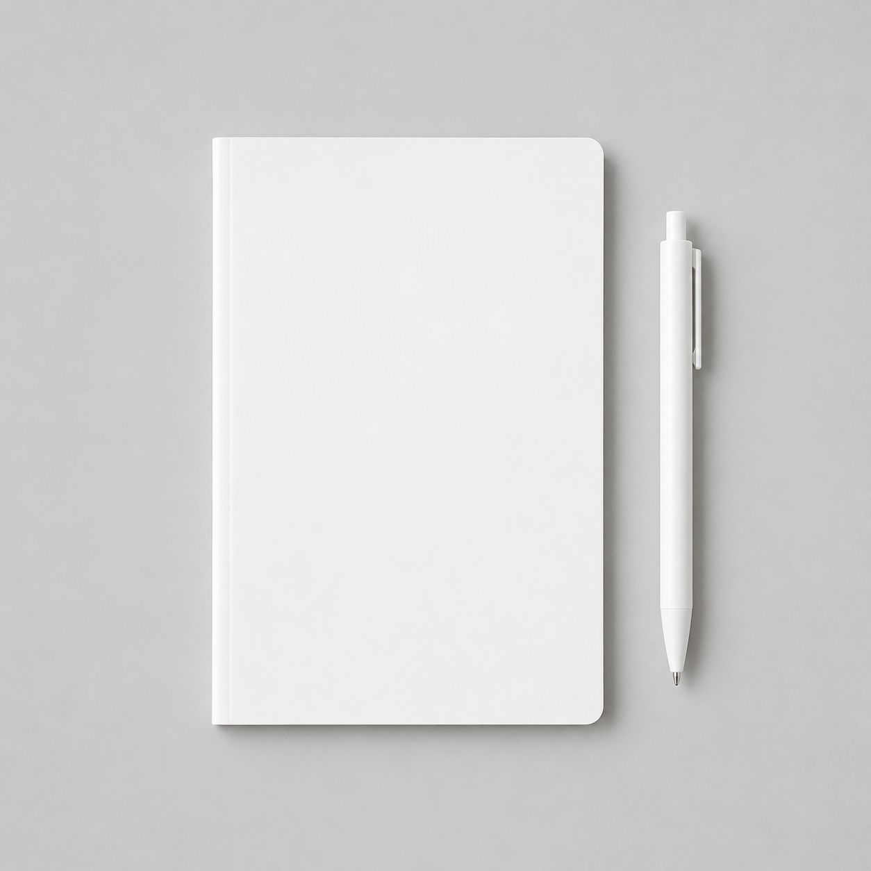 White notebook and pen arranged neatly on a light grey background